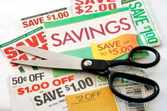 black scissors on top of a pile of coupons