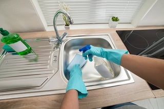 person cleaning kitchen sink