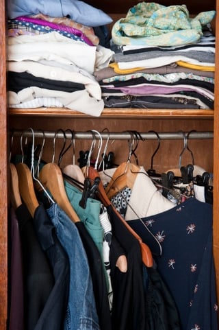small_closet_with_clothes_hanging_and_folded_on_shelf