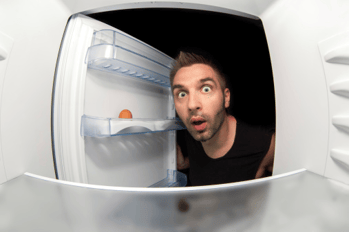 man looking in fridge